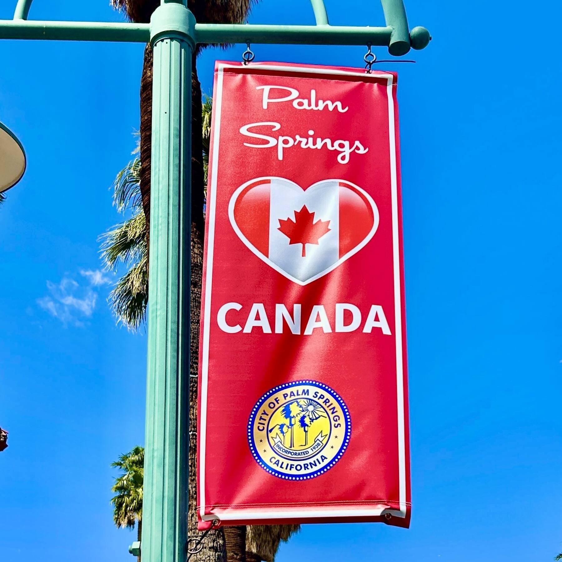 Red banner on lamppost, text with a heart and Canadian flag.