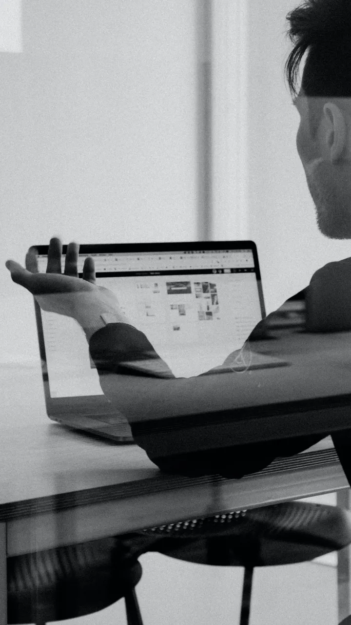 Black and white photo of two people sitting at their laptops