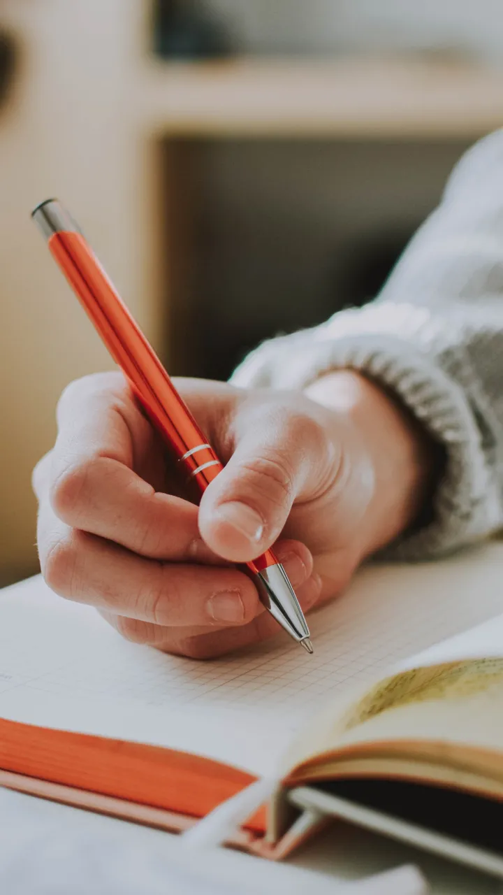Close up view of a hand holding a pen and writing