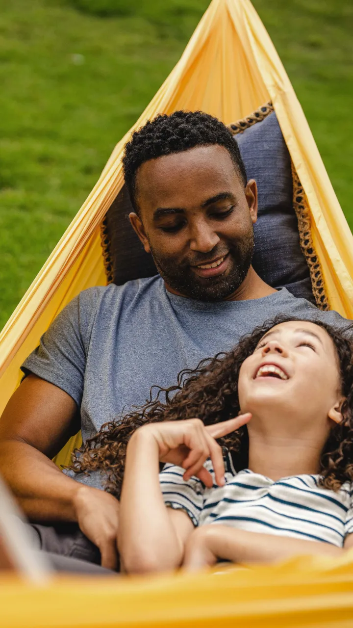 A dad and daughter in a hammock