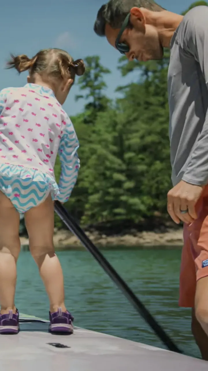 Father and daughter standing on paddle board