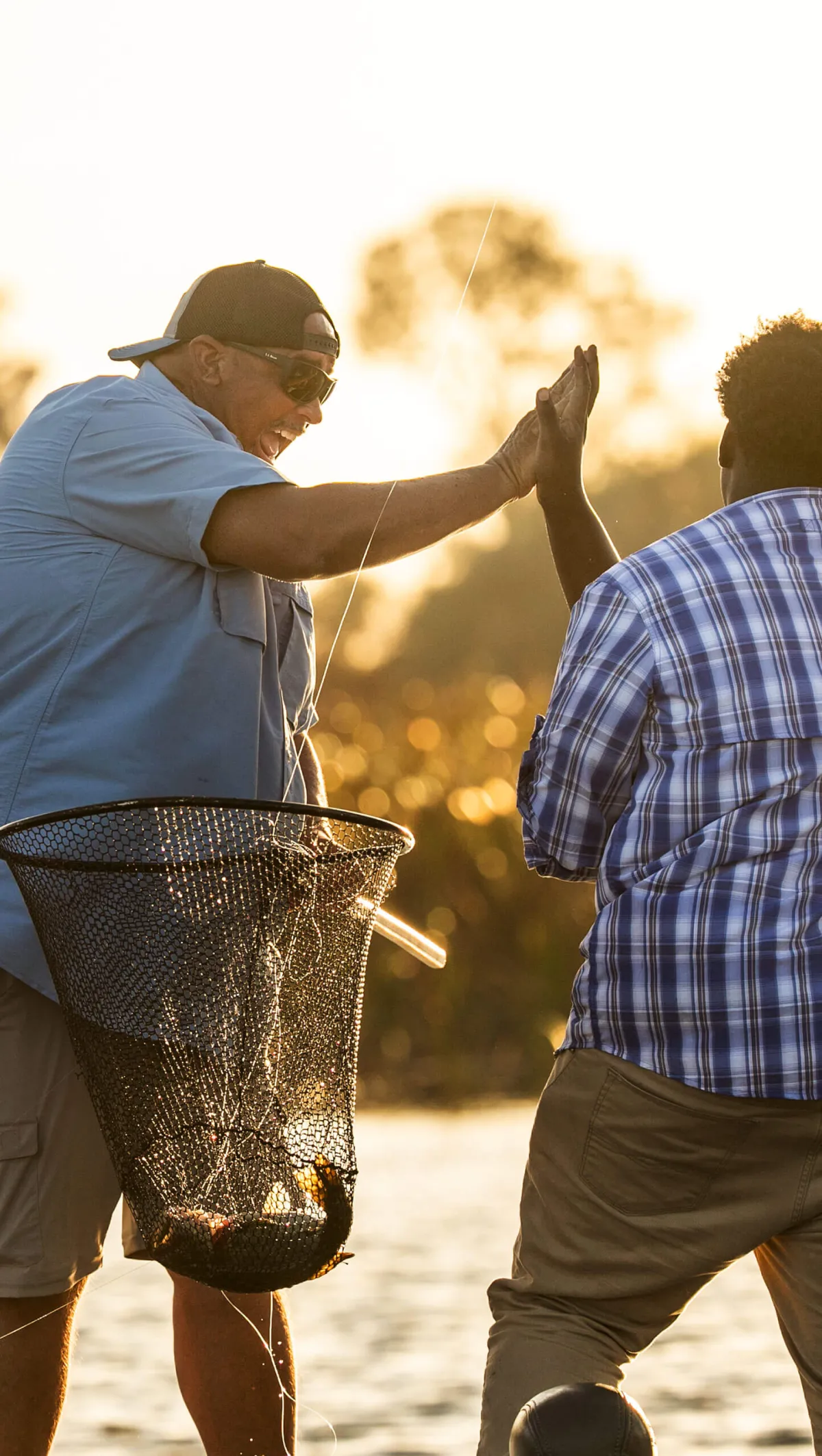 Friends high-fiving while fishing