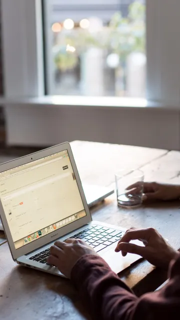 man typing on computer at a table