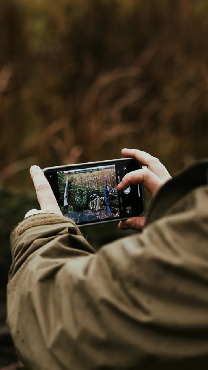 A close up of someone taking a photo with an iPhone