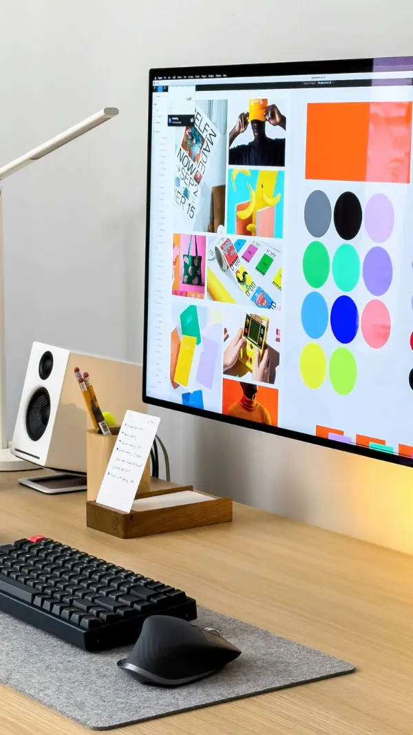 Modern desk setup with computer displaying colorful graphics.