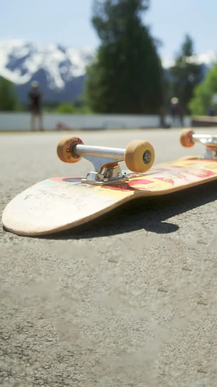 Skate board on ground with mountains in the background
