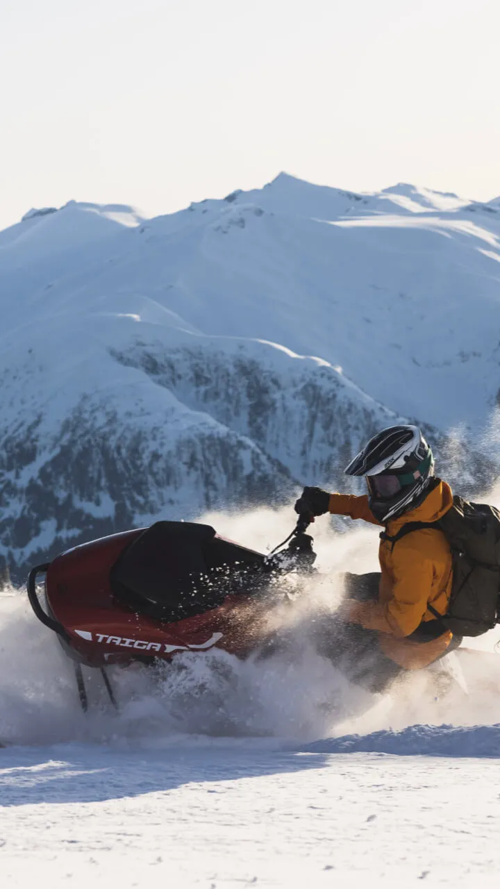 Taiga snowmobile plowing through snow