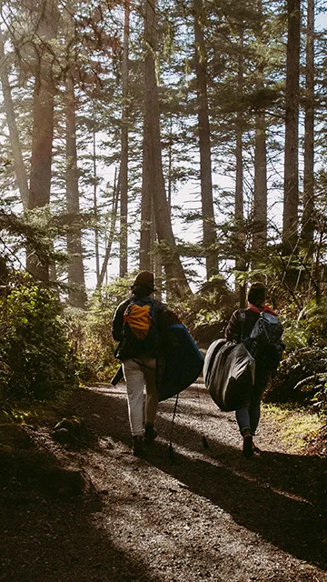 Two people walking on a path in the forest