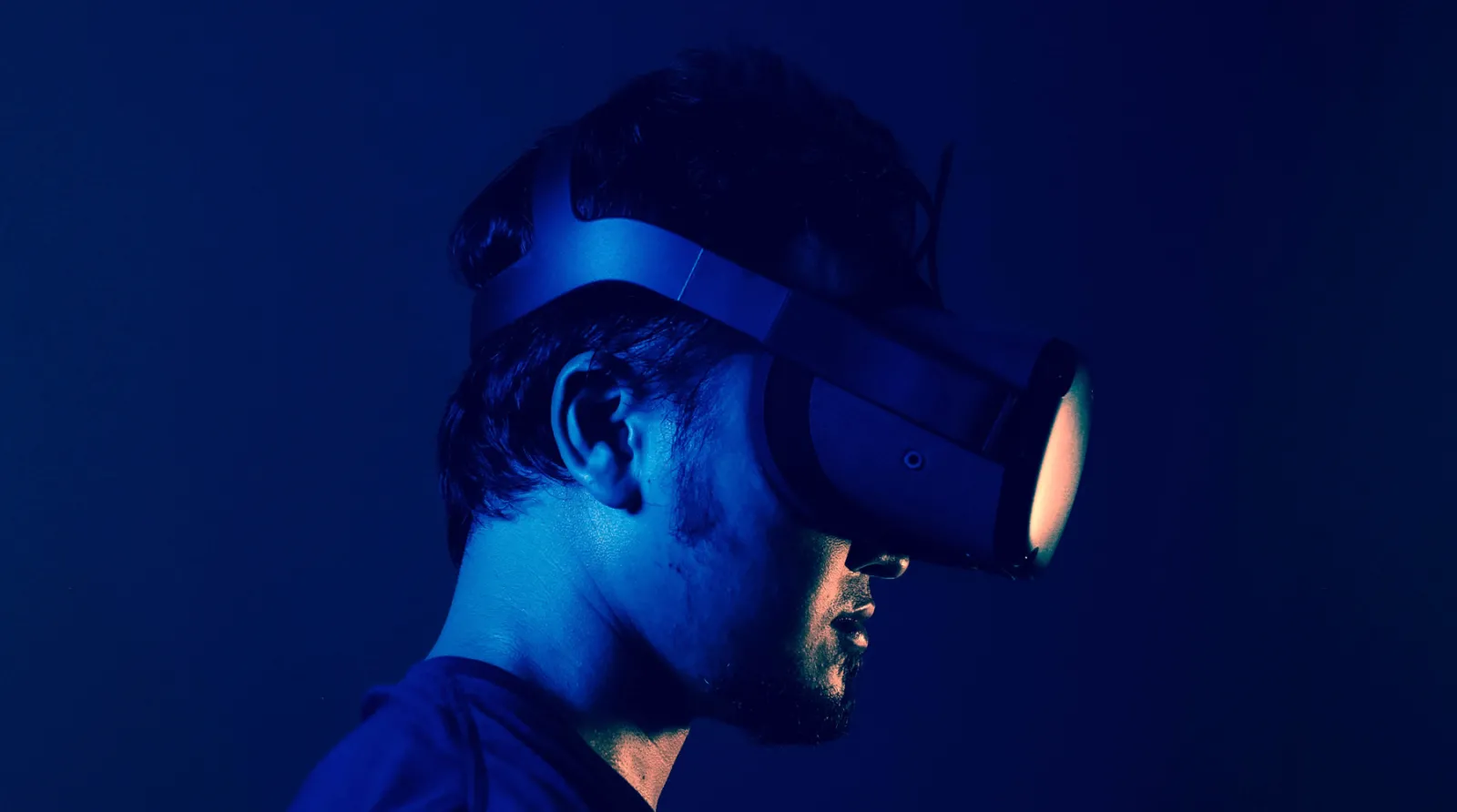 Blue lit person wearing VR glasses