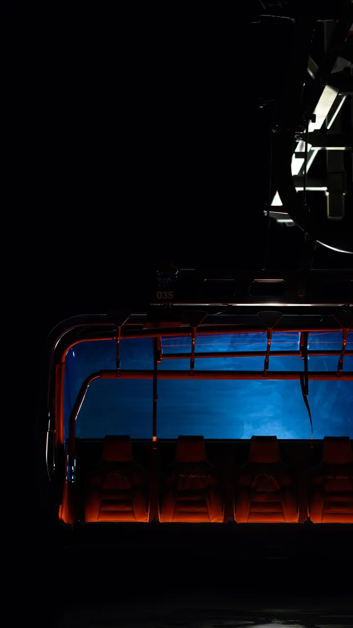 Dark industrial structure with blue and orange lighting.