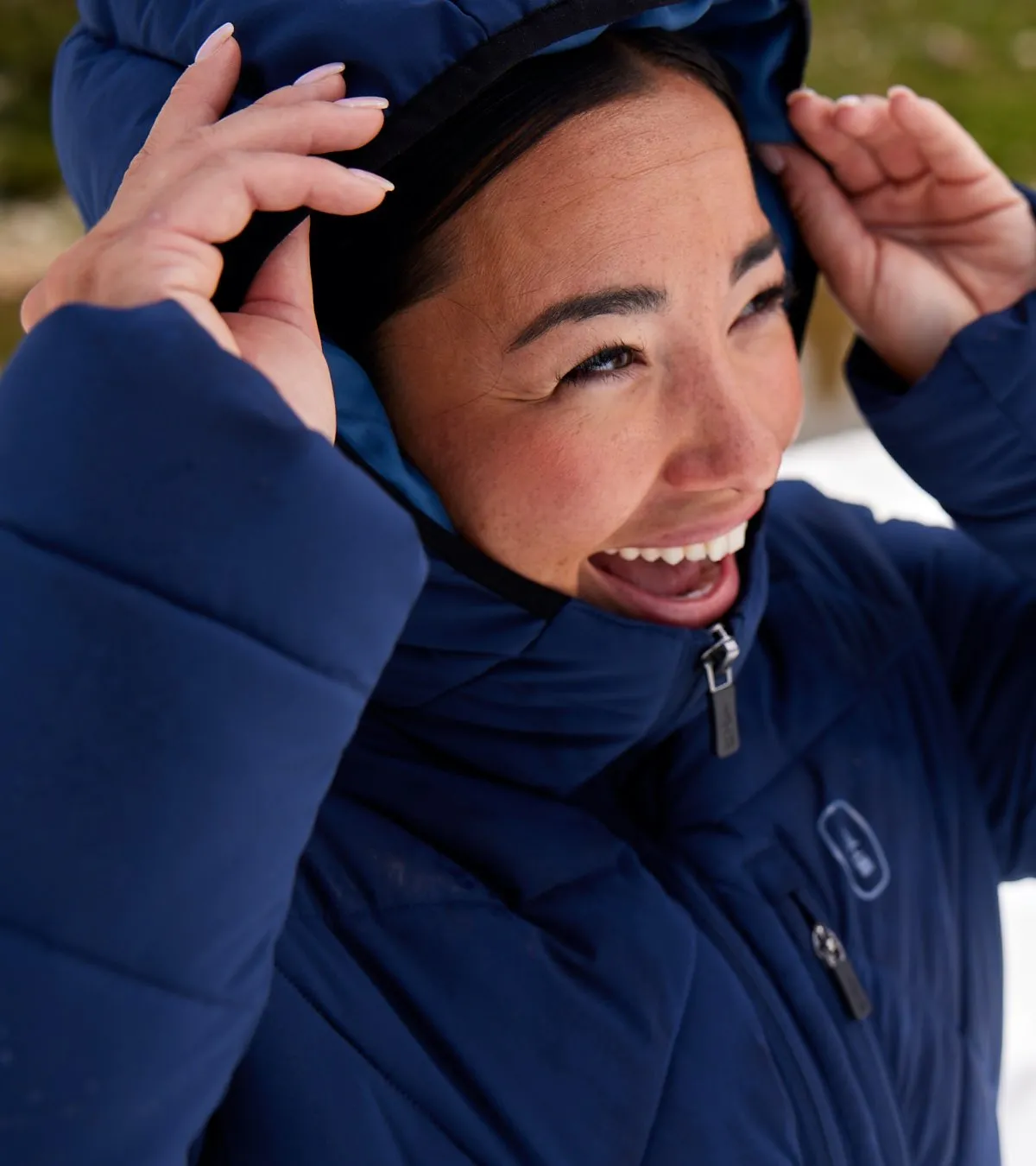 Person lifting hood and smiling