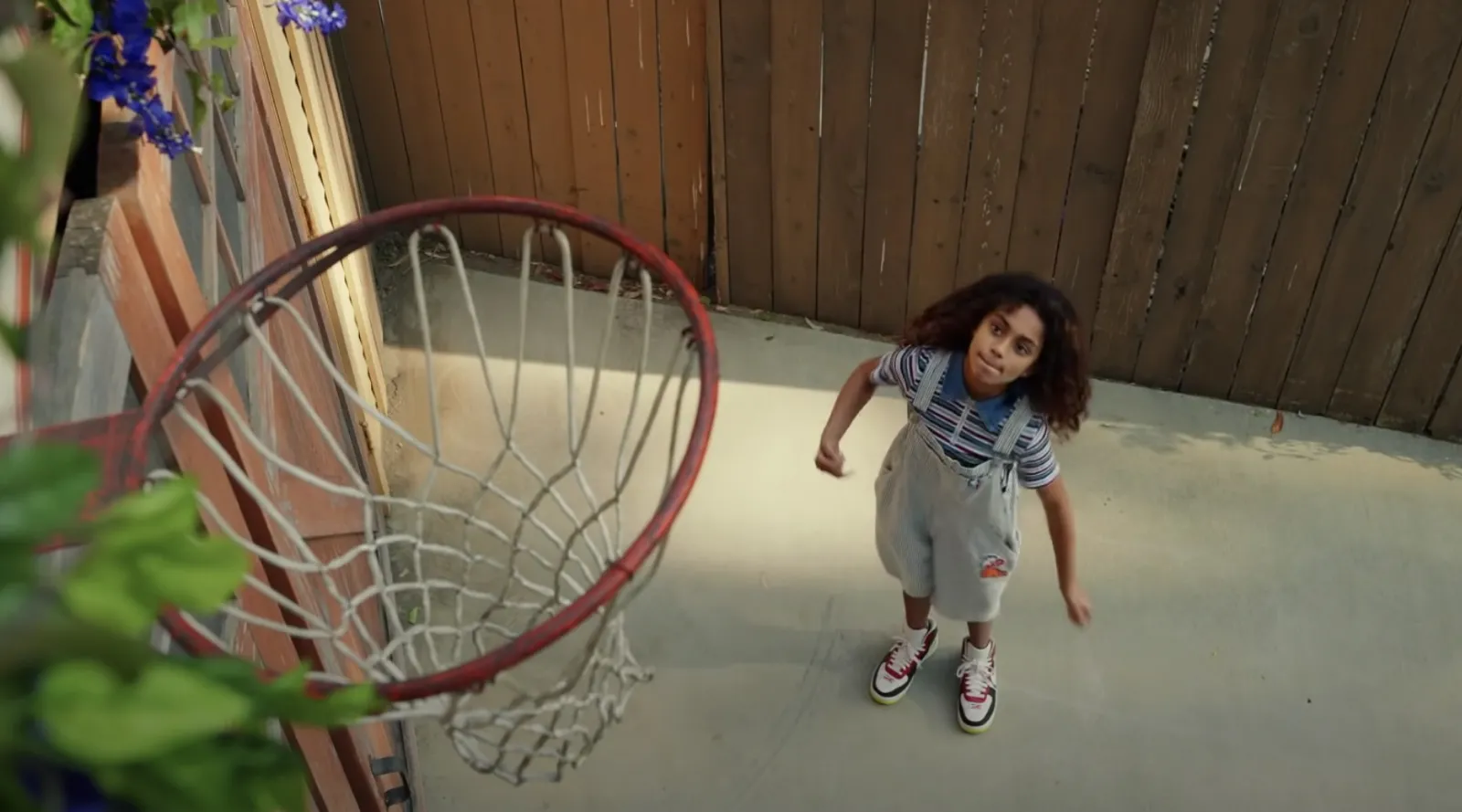 young girl playing basketball in driveway