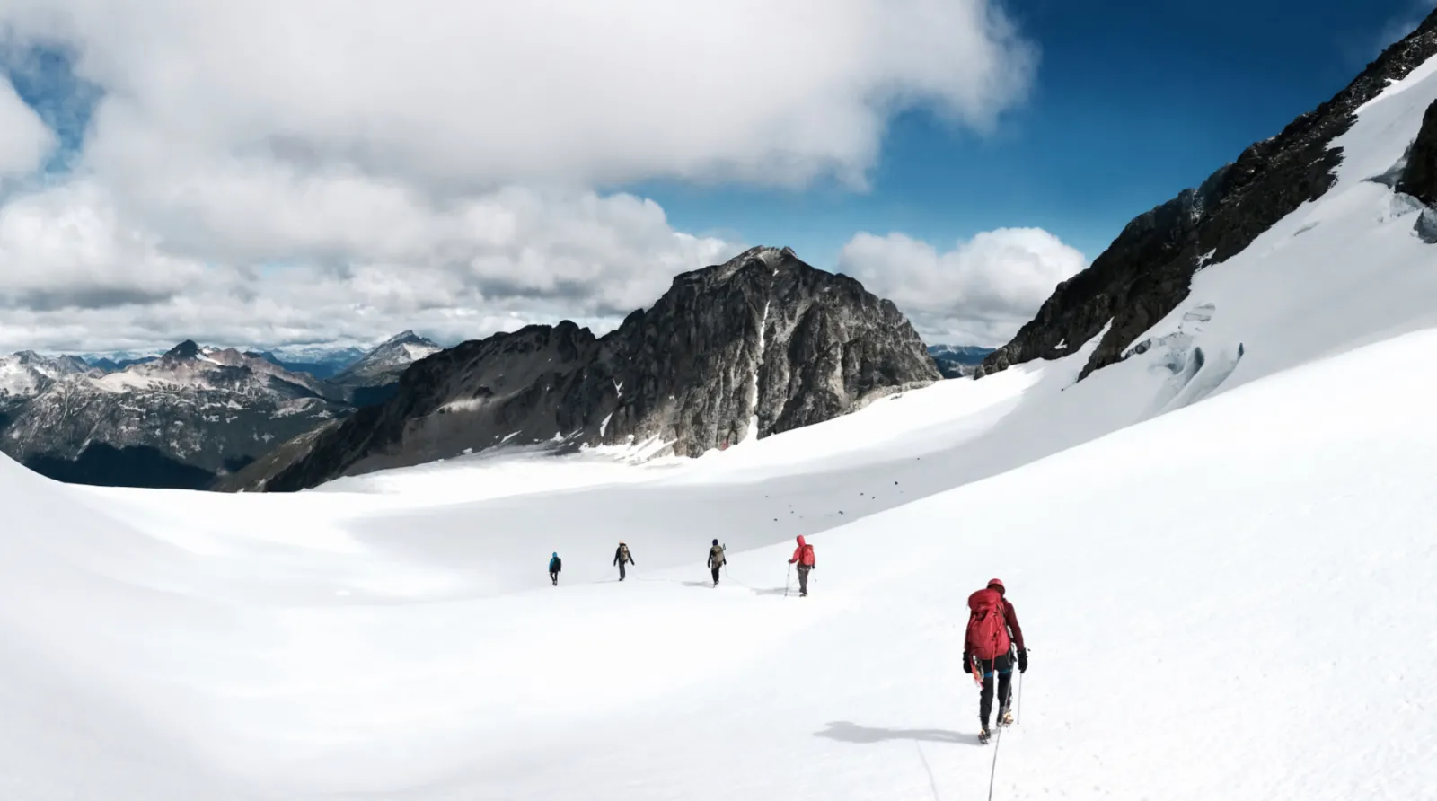 5 people mountaineering in the winter and mountains surrounding