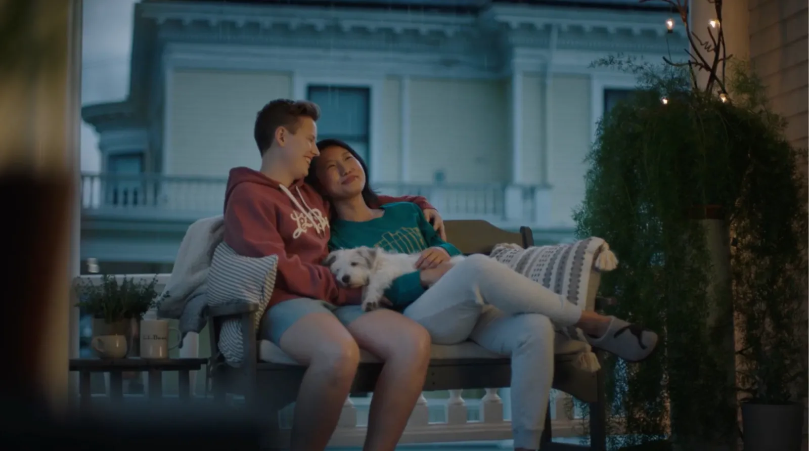 Couple sitting on a bench outside their house