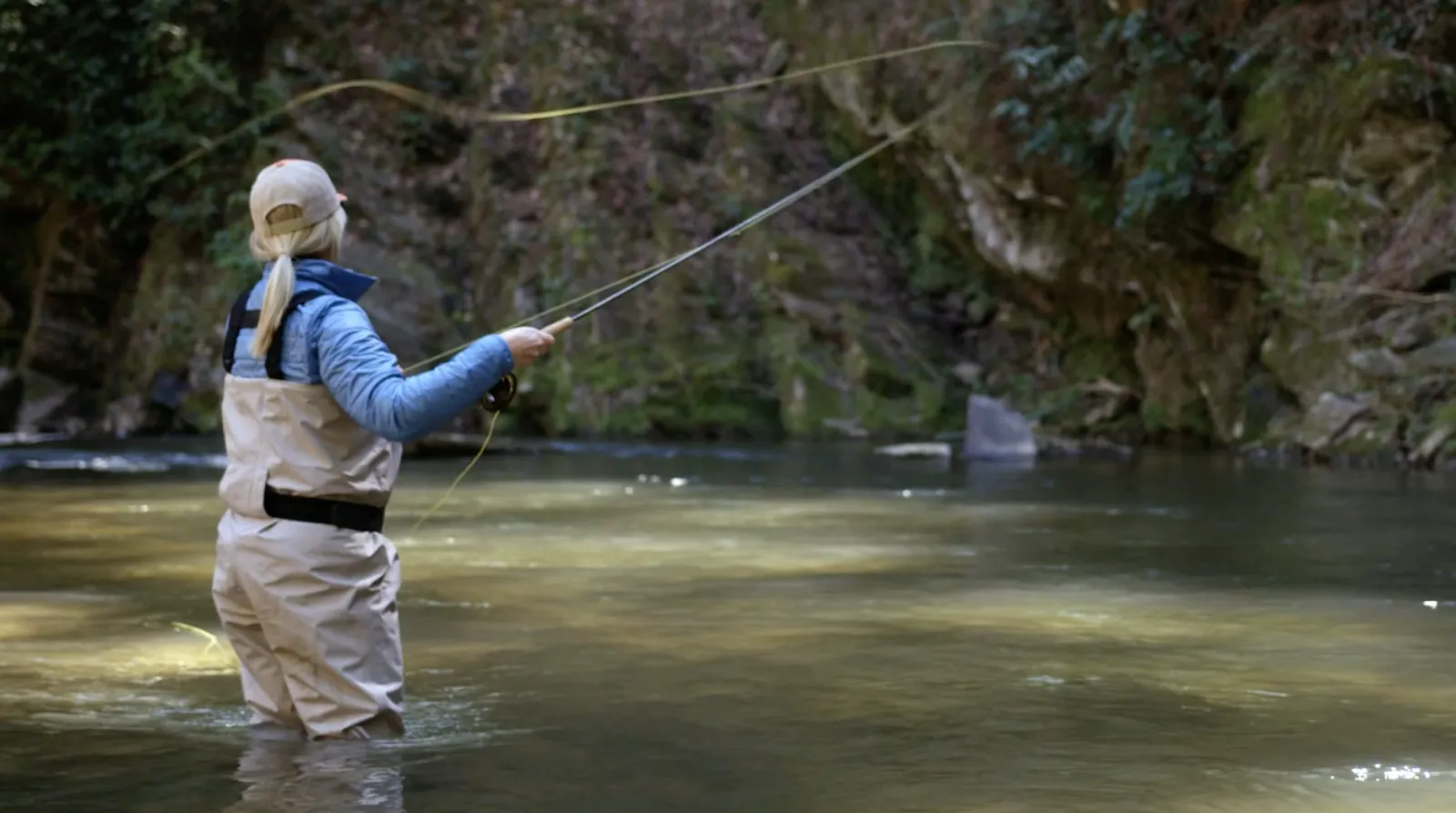 someone in waders fly fishing