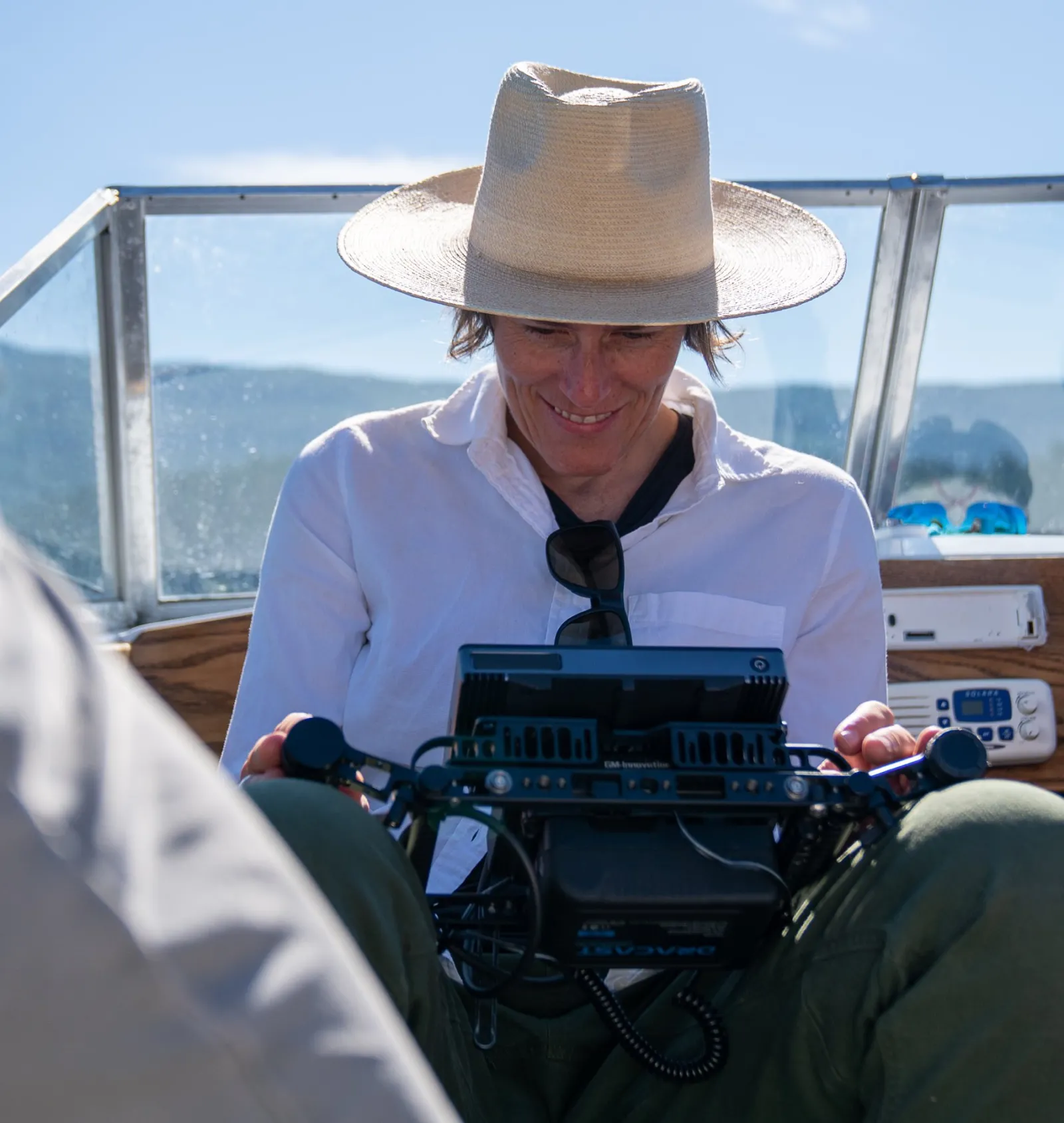 Andrea Wing smiling while reviewing footage, sitting in a boat