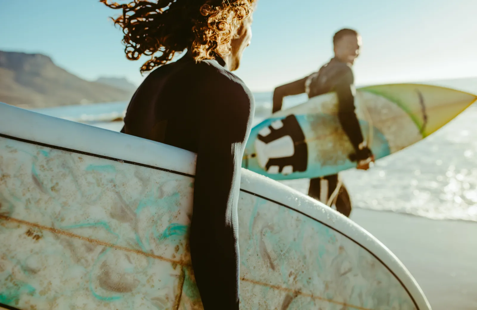 surfers run to the waves