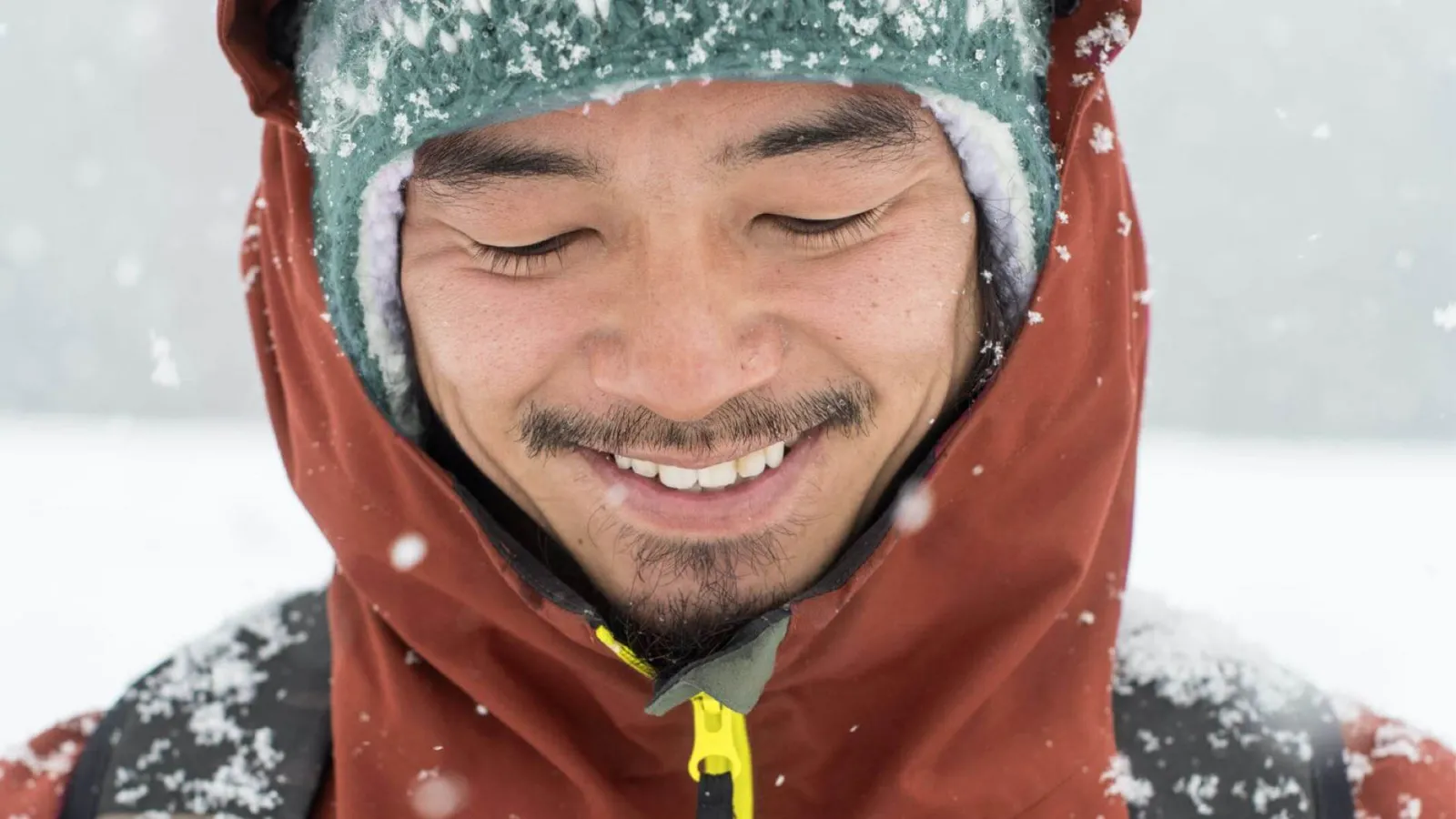 Man standing in snow while smiling