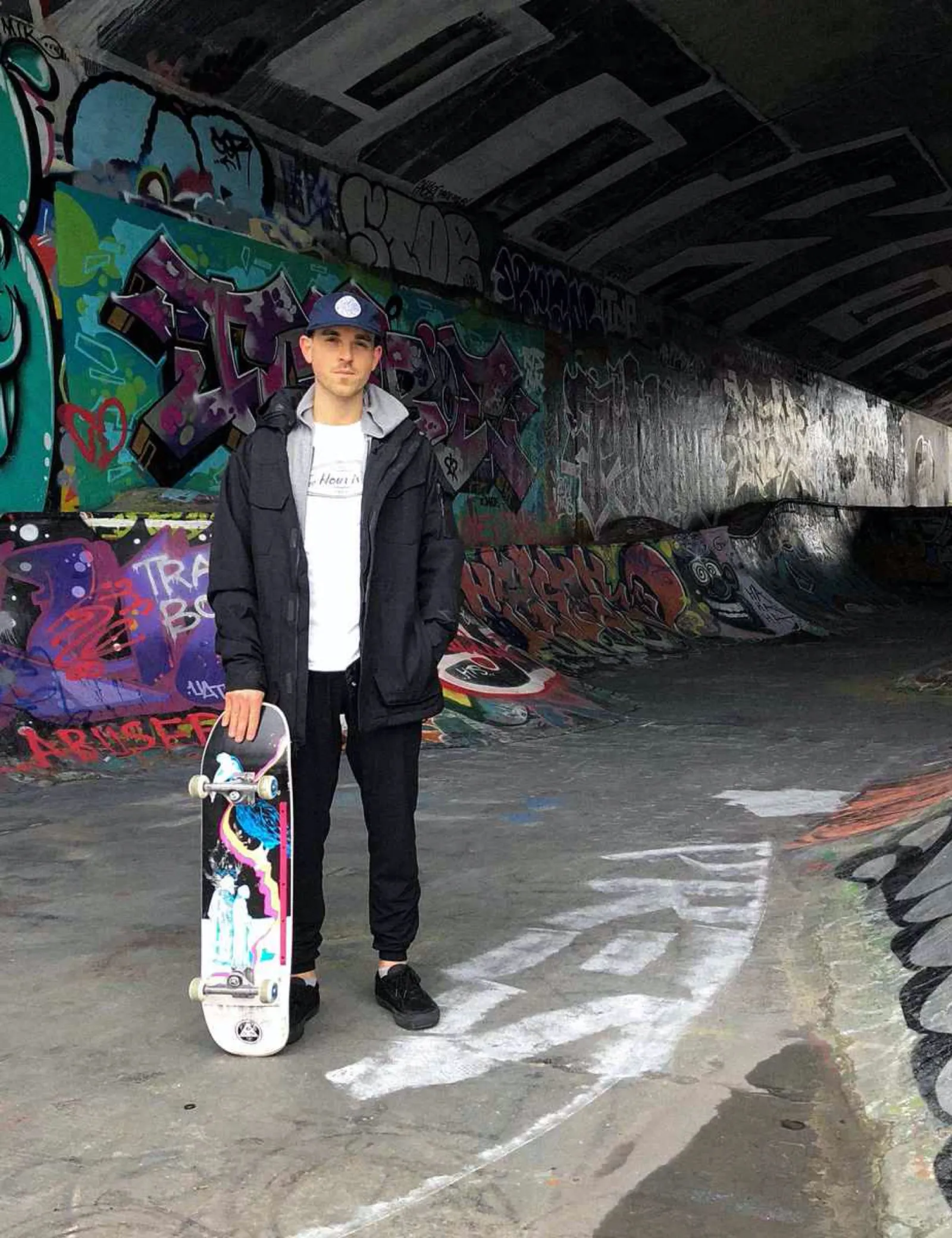 Steve standing with his skateboard