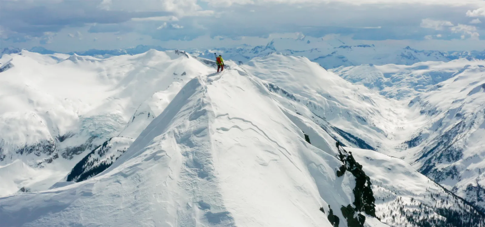 Backcountry skiier atop a peak