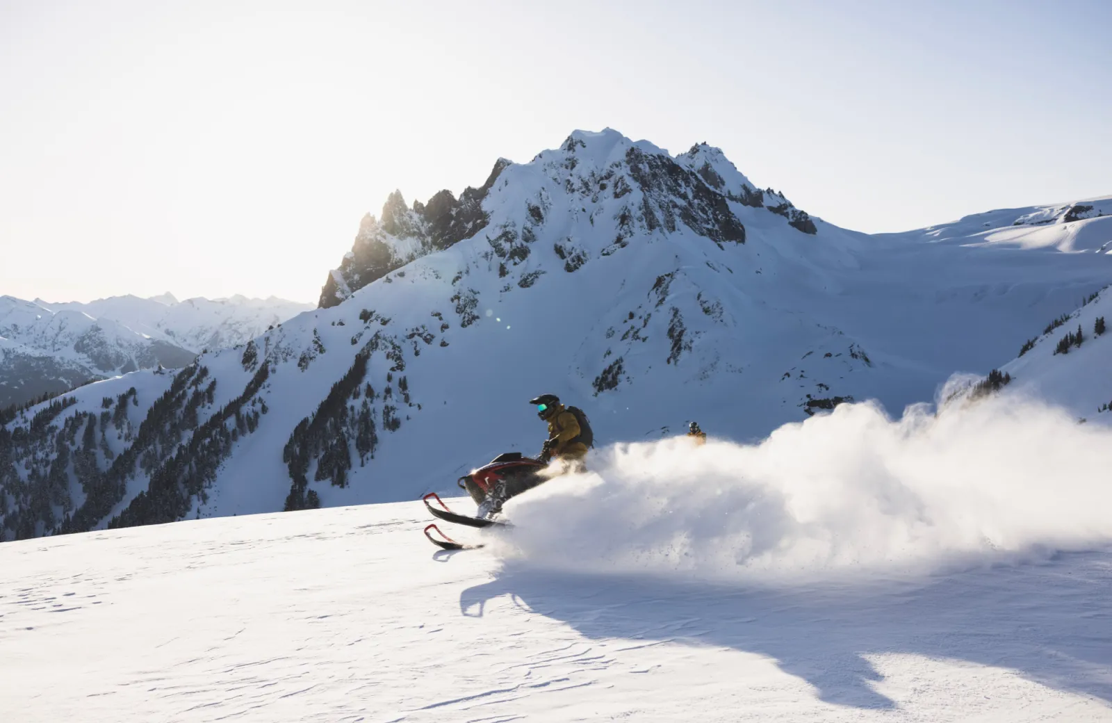 Man rides snowmobile through mountains