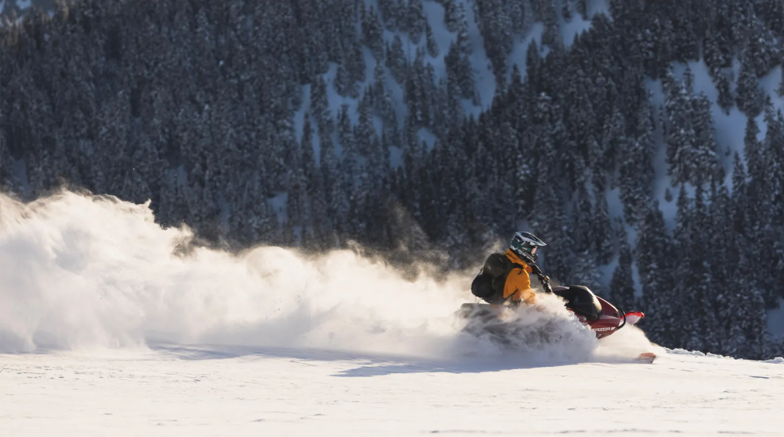 Man rides snowmobile through mountains