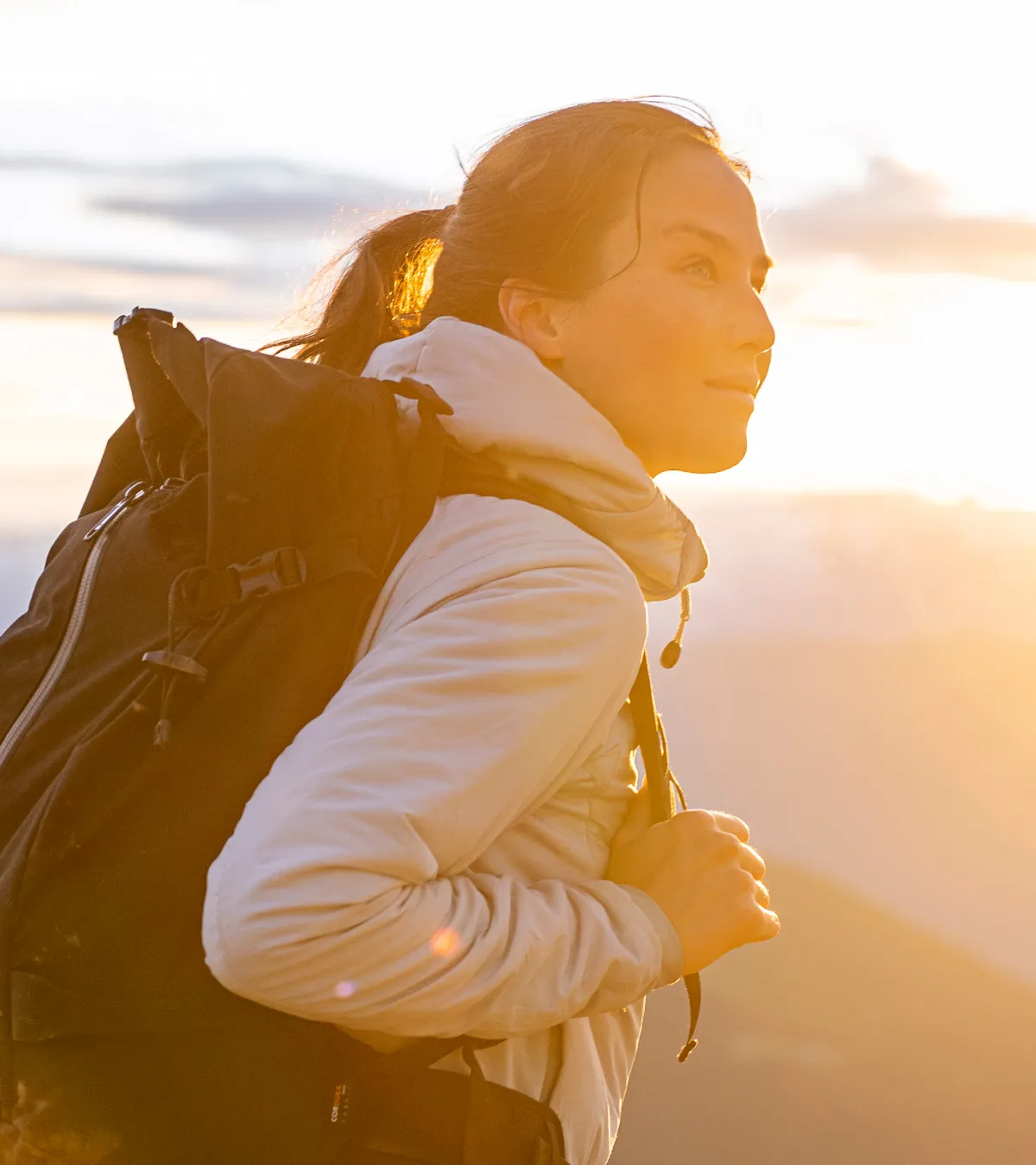 Girl looking at sunset hiking in the alpine