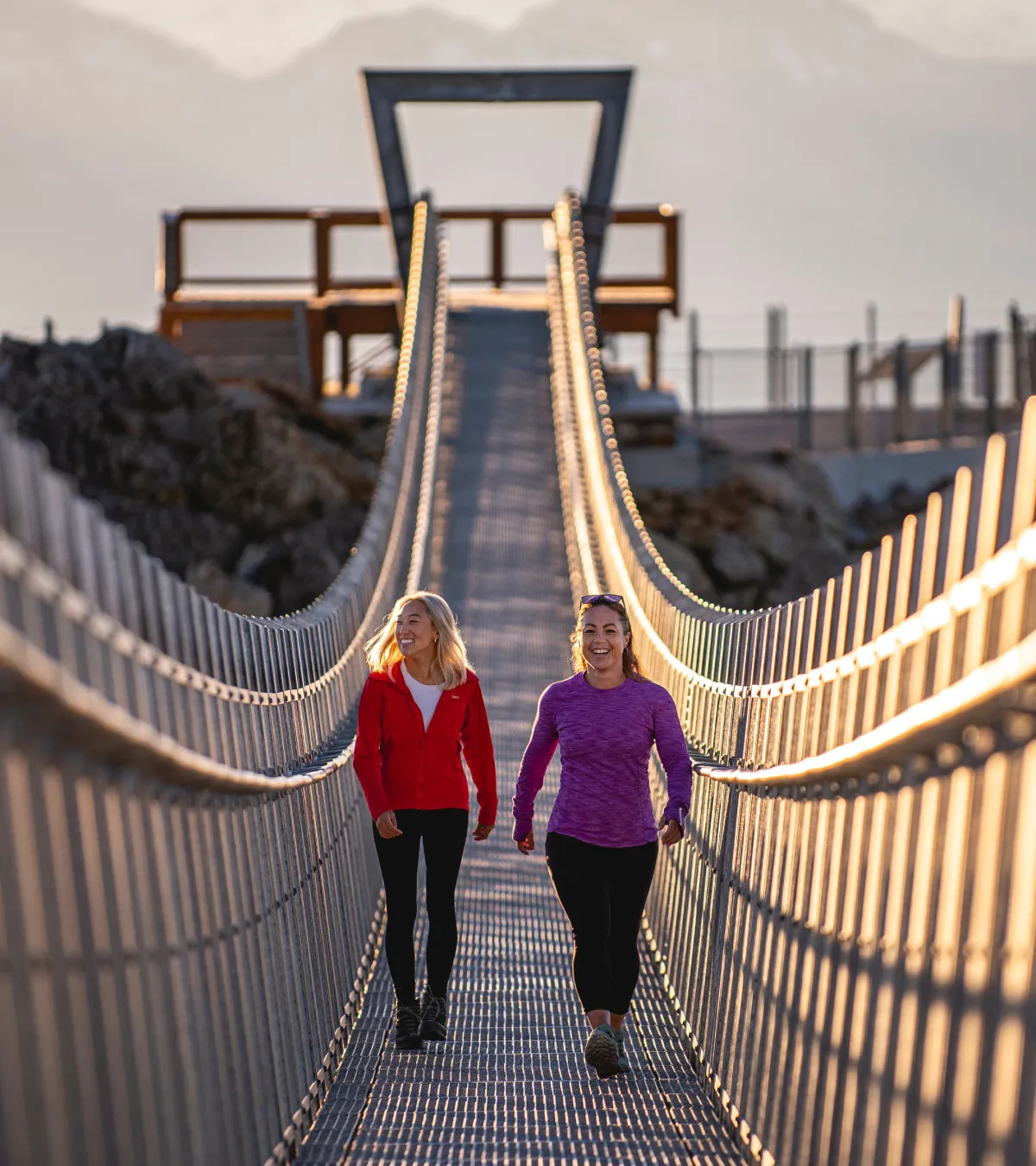 2 girls walking across sky bridge in whistler