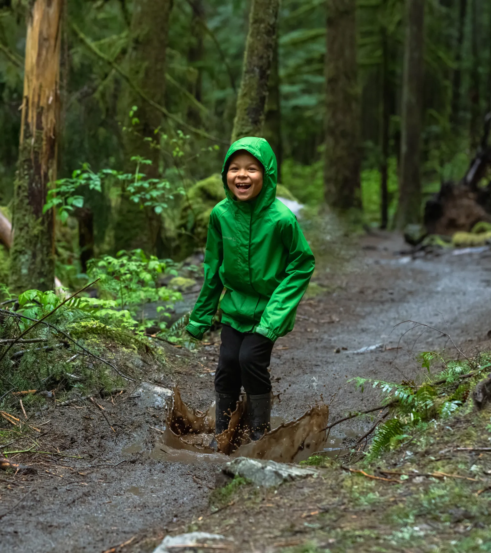 A kid jumping in a puddle