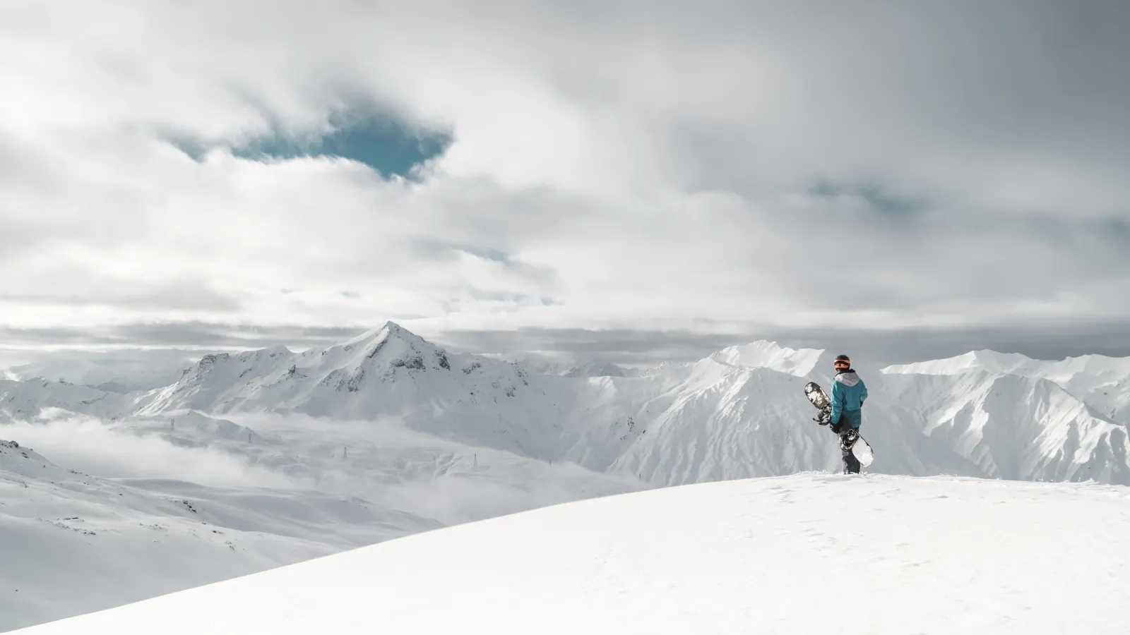 Person standing on edge of white snow cliff