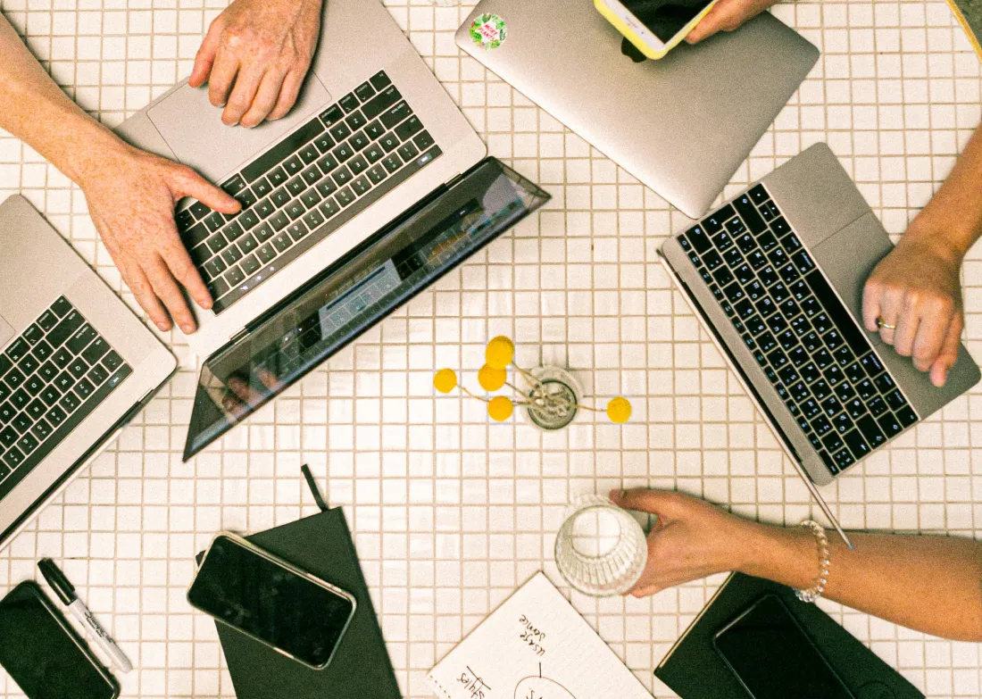 People sitting around a table on computers