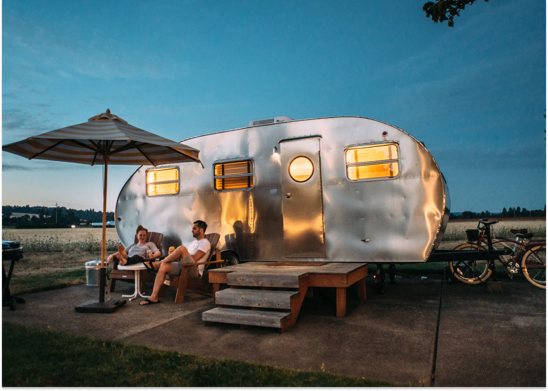 couple sitting outside of a camper