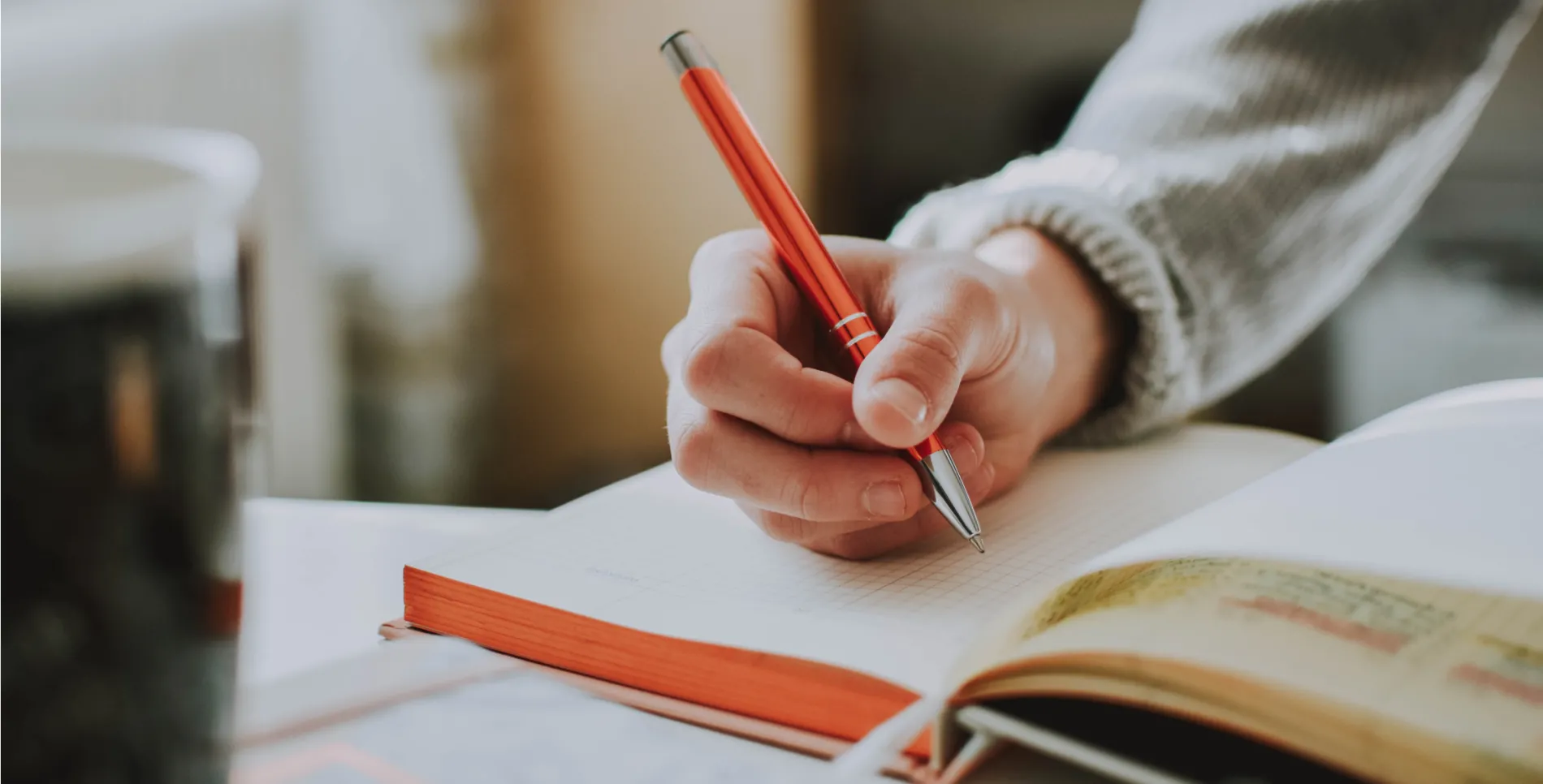 Close up view of a hand holding a pen and writing