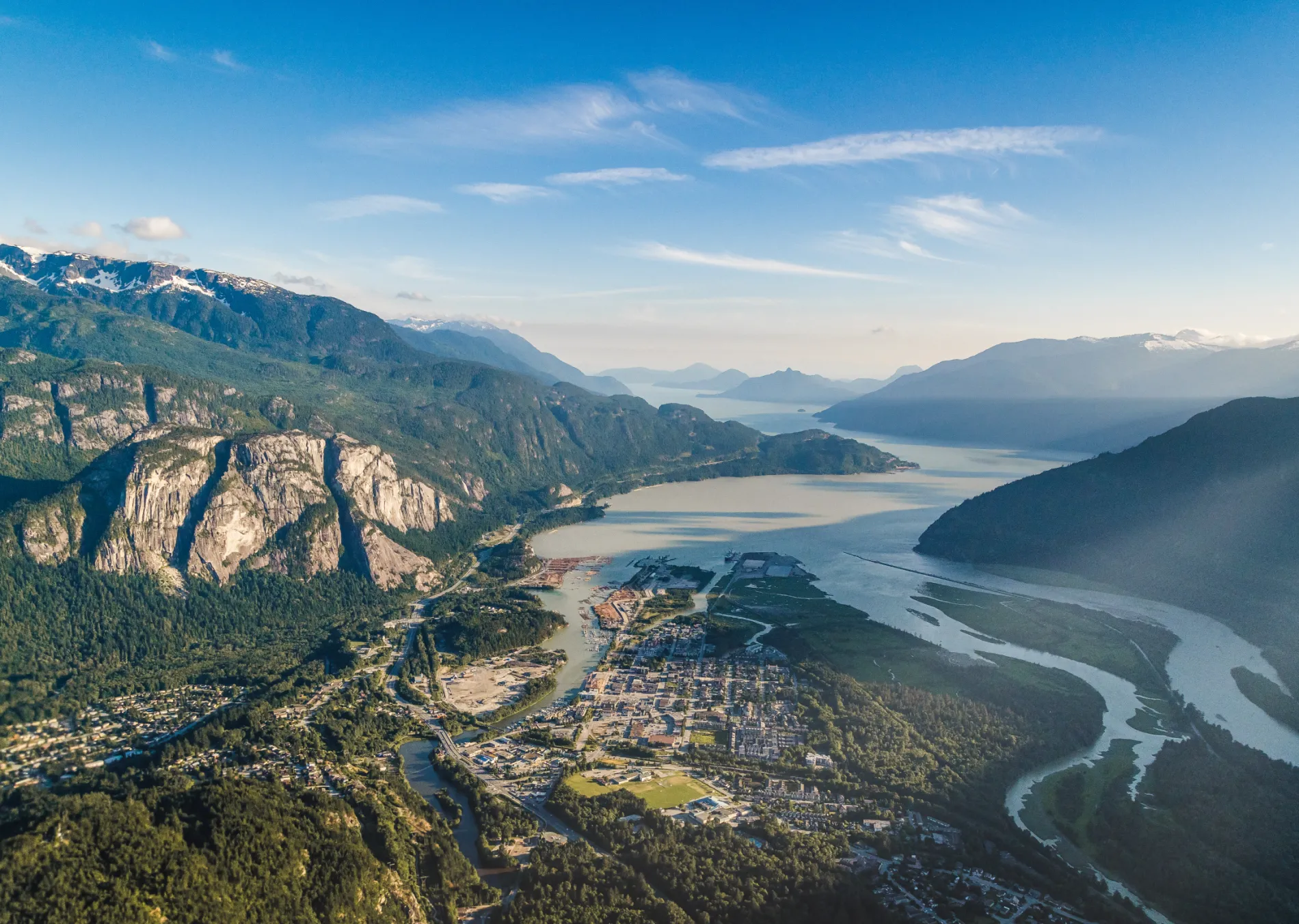 Aerial view of a mountainous landscape with a winding river and lush greenery.