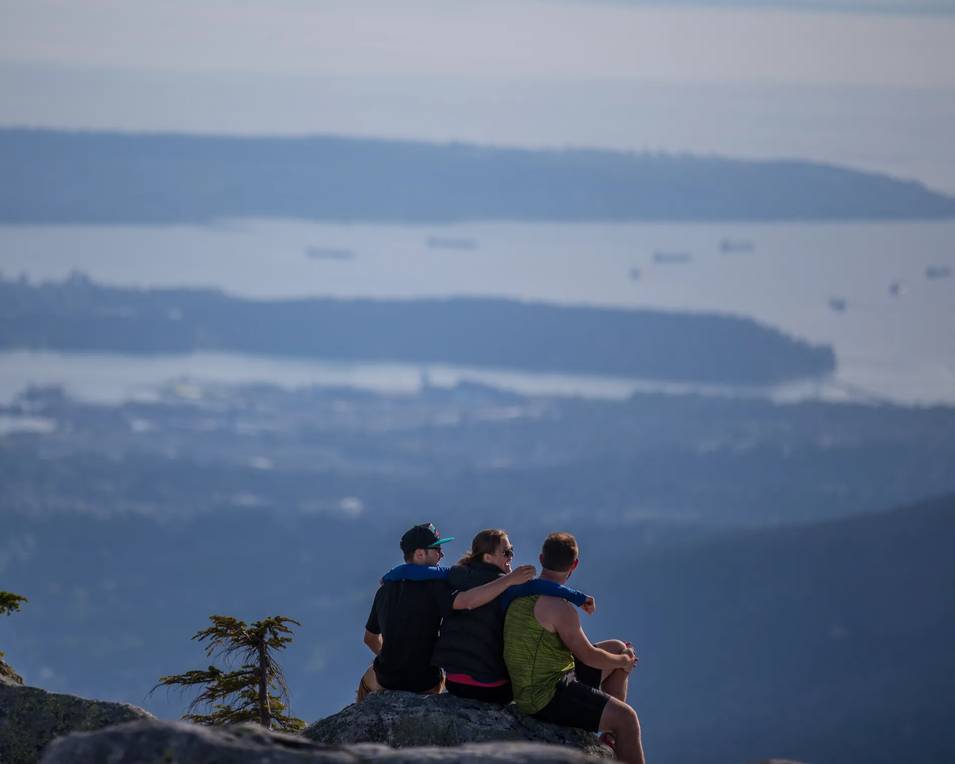 People sitting on a rocks overlooking the ocean