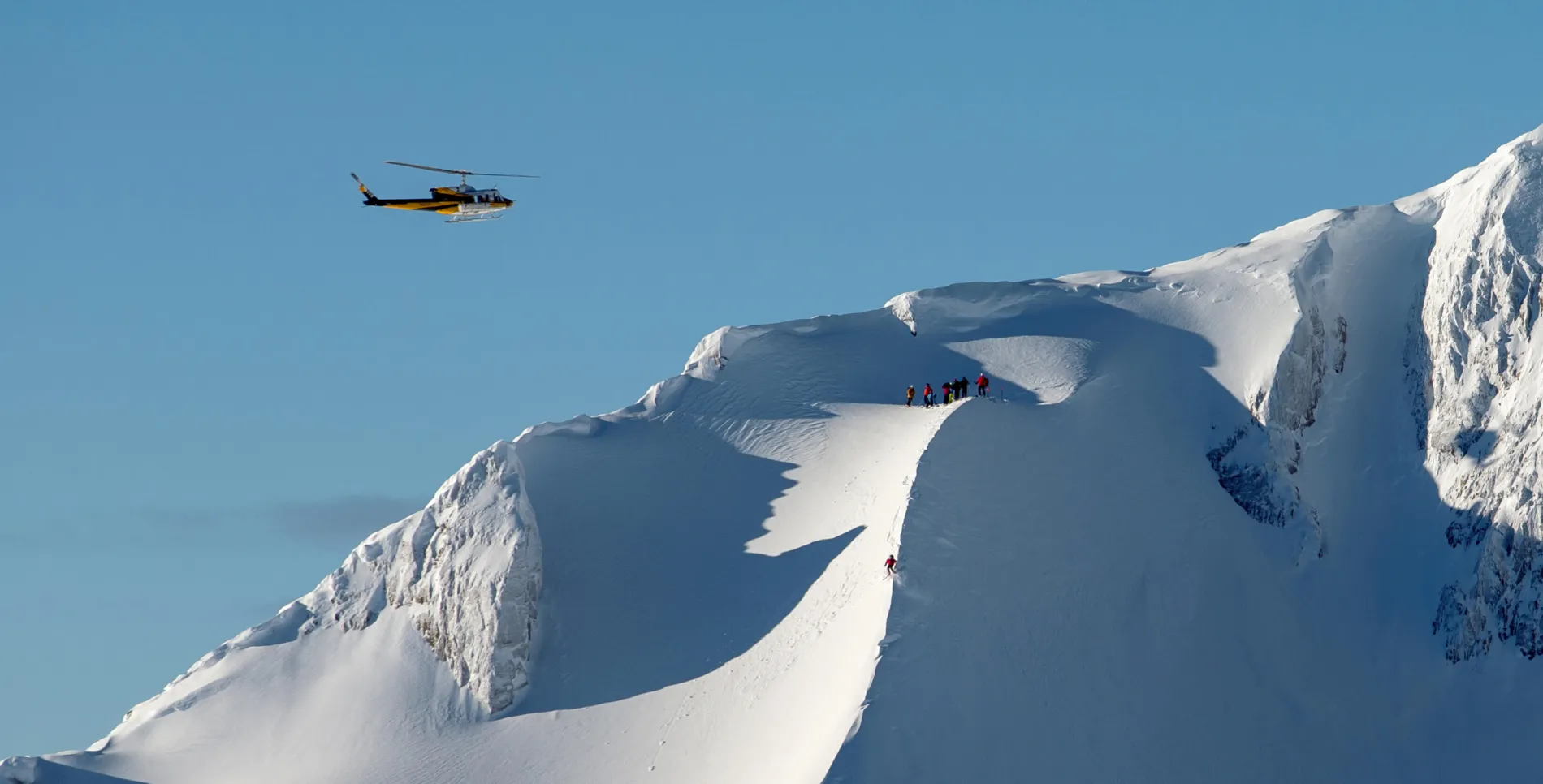 helicopter flying over skiers