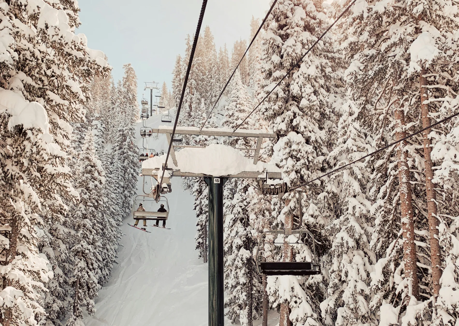Two people on a chairlift in the distance