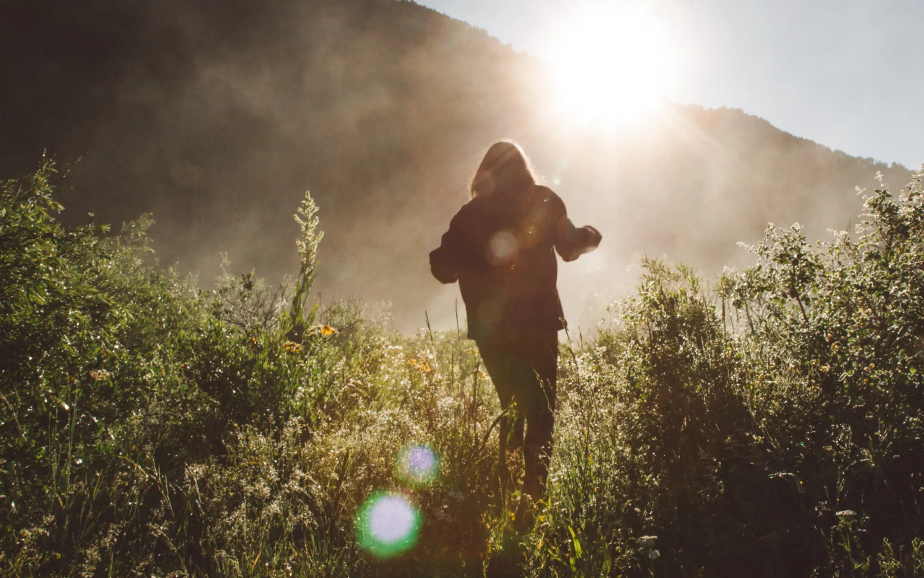 Girl walking through an alpine field