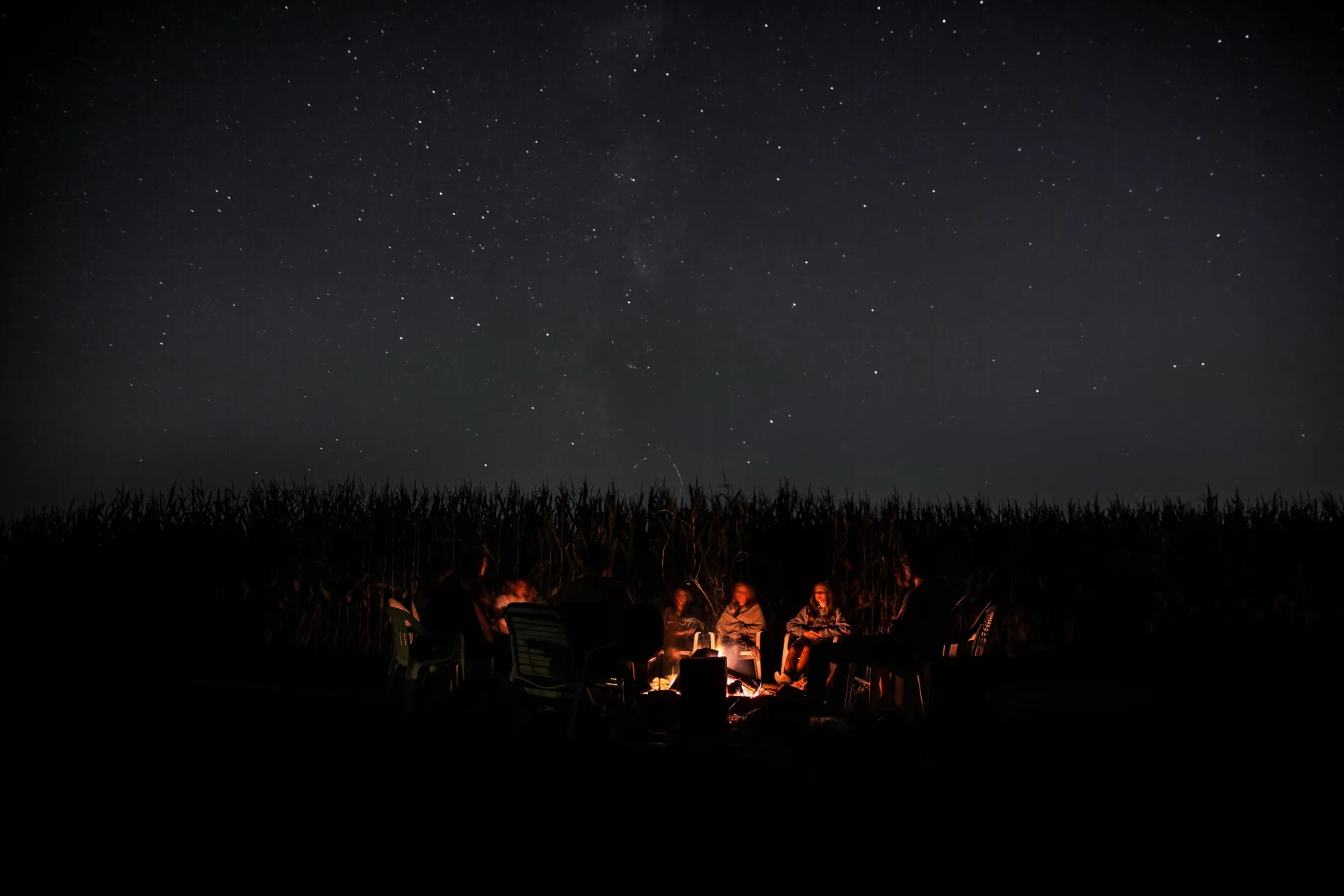 People sitting around a campfire at night